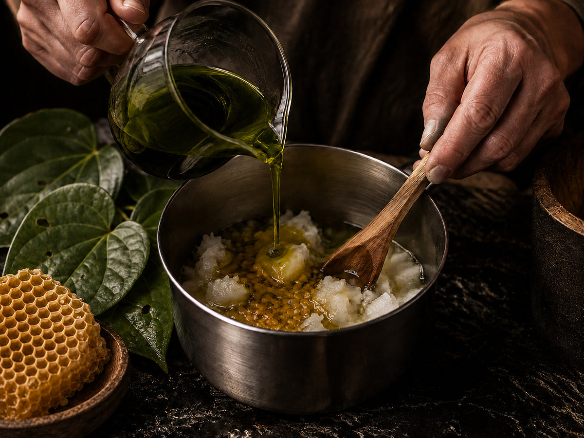 Hands stirring kawakawa-infused oil into the balm blend