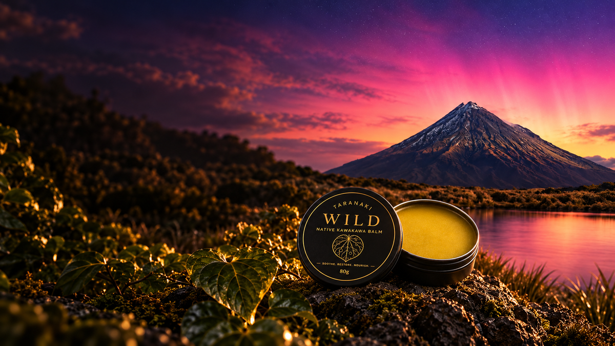 Taranaki Wild 80g Kawakawa Balm on volcanic rock beside the lake beneath Mount Taranaki at sunset
